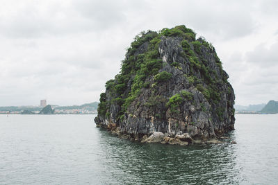 Rock formation in sea against sky