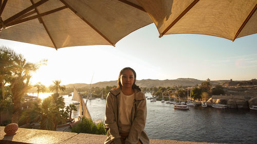 Asian tourist woman at nile river bank sunset in aswan egypt dream exotic trip to africa