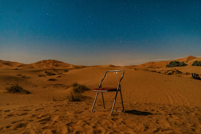 Lifeguard hut on desert against sky at night