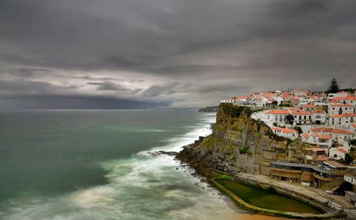 Scenic view of sea and buildings against sky