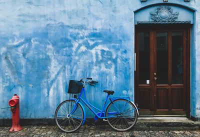 Bicycle parked against wall of building