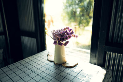 Close-up of flower vase on table by window