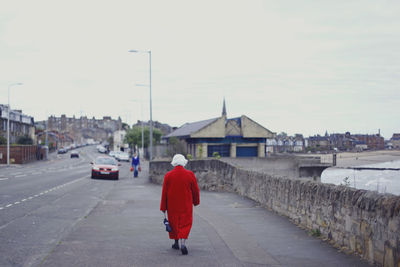 Rear view of man standing on road