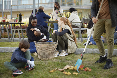 Neighbors relaxing and raking leaves in communal outdoor area