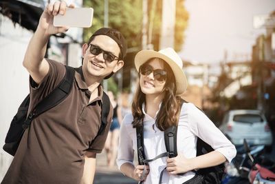 Man taking selfie with friend in city