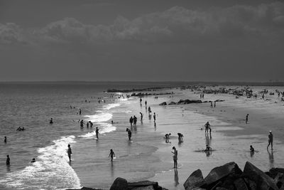 People at beach against sky