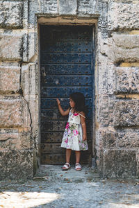 Portrait of woman standing against old building