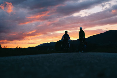 Silhouette men against sky during sunset