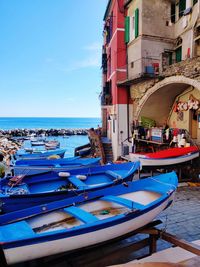Boats moored on sea against buildings in city