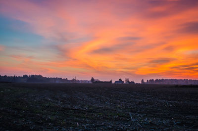 Scenic view of field against orange sky