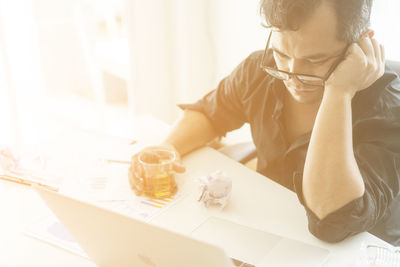 Businessman with having drink at desk in office