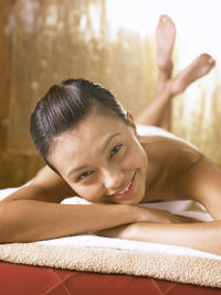 Close-up portrait of young woman lying on bed