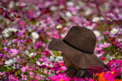 Close-up single woman and of pink flowers in field