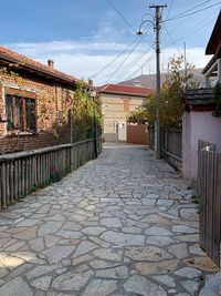 Footpath amidst buildings against sky