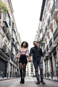 Full length portrait of young couple standing in city