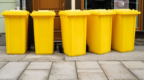 Yellow glasses on footpath against wall