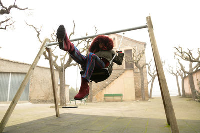 Young girl sheltered in abandoned swing set, unrecognisable