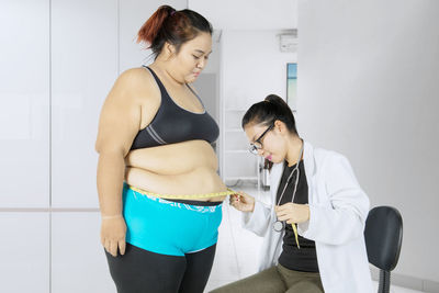 Doctor examining overweight patient at hospital