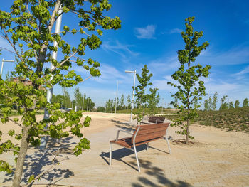 Chair on sand against sky