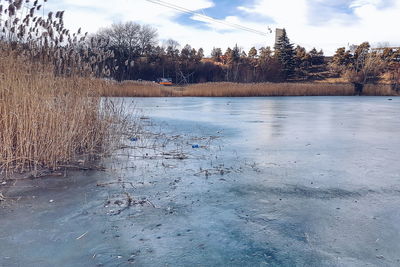 Frozen lake against sky during winter