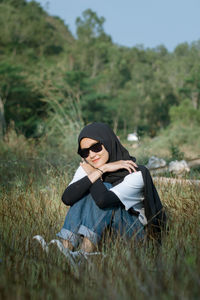 Young woman sitting on field