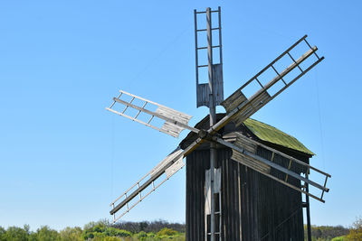 Low angle view of traditional windmill against clear blue sky