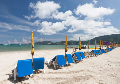 Chairs on beach against sky