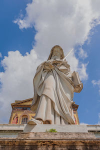 Low angle view of statue against building against sky