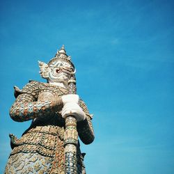 Low angle view of statue against blue sky