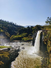 Scenic view of waterfall against clear sky