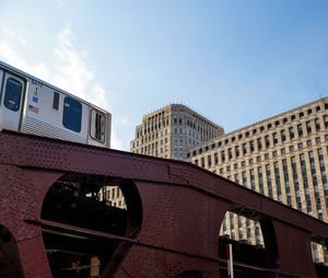 Low angle view of train against buildings in city