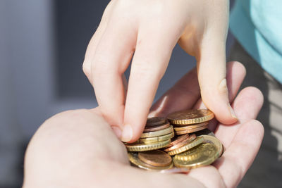 Cropped hand of woman giving coins to friend