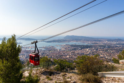 Overhead cable car and buildings against sky