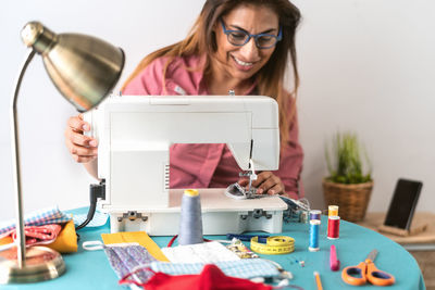 Portrait of woman using smart phone while sitting on table