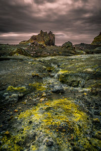 Rock formations by sea against sky during sunset