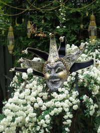 Close-up of statue by plants in garden