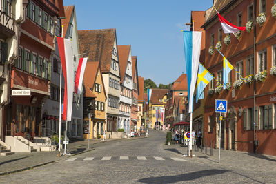 Road amidst buildings in city against clear sky