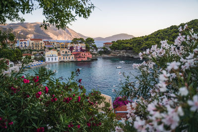 Scenic view of sea by houses and mountains against sky
