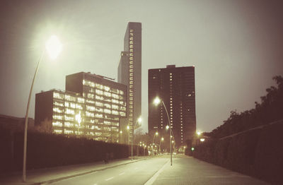 View of city lit up against clear sky