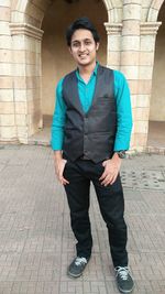 Full length portrait of smiling young man standing at vardhman fantasy amusement park