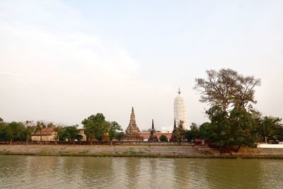 View of building by river against sky