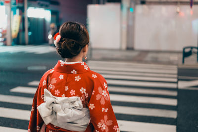 Rear view of woman standing on street