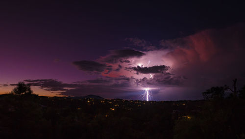 Lightning over illuminated city at night