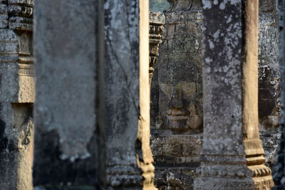 Columns against buddha head carved on bayon temple