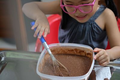 Close-up of cute girl preparing food on table