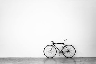 Bicycle against white wall