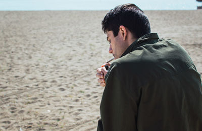 Man igniting marijuana while sitting in desert