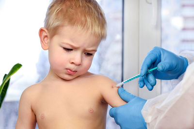 Doctor vaccinating child. coronavirus vaccination in arm of little boy. little boy getting flu shot.