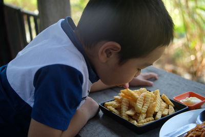 Close-up of boy licking food in plate on table