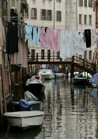 Clothes drying on clothesline over canal in city